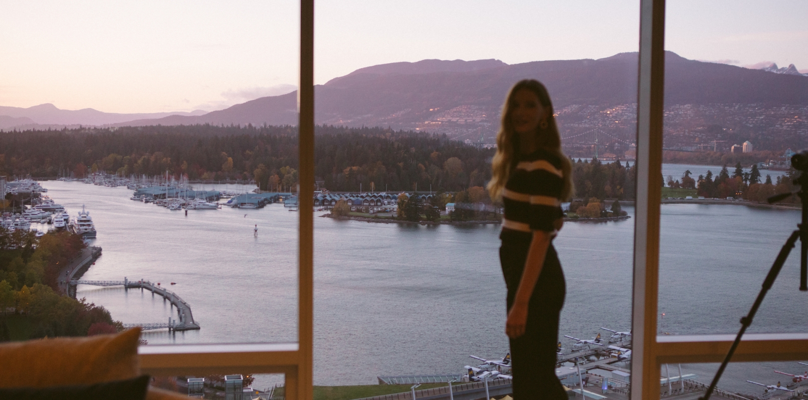 Woman in front of floor to ceiling windows with ocean view