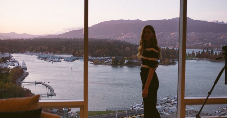 Woman in front of floor to ceiling windows with ocean view