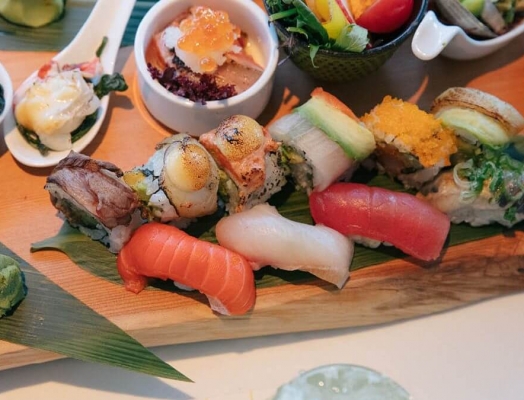 Sushi and sashimi on a wooden board.