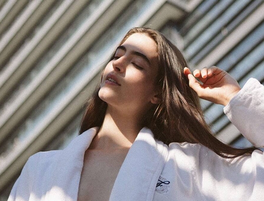 A women in a Fairmont Hotel robe in the sunlight