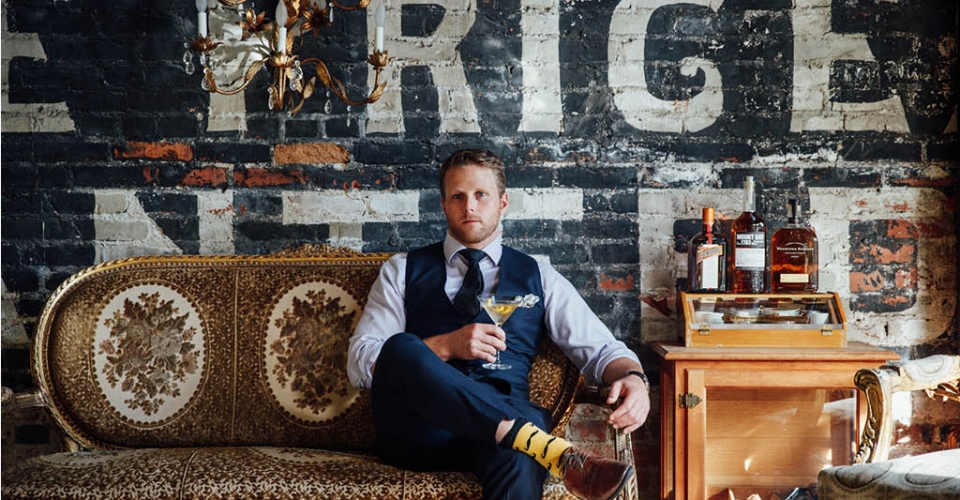 well dressed man holding a drink