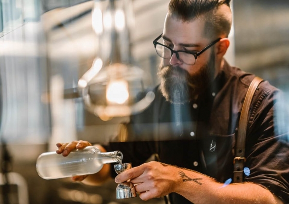 A man measuring a spirit in a jigger.