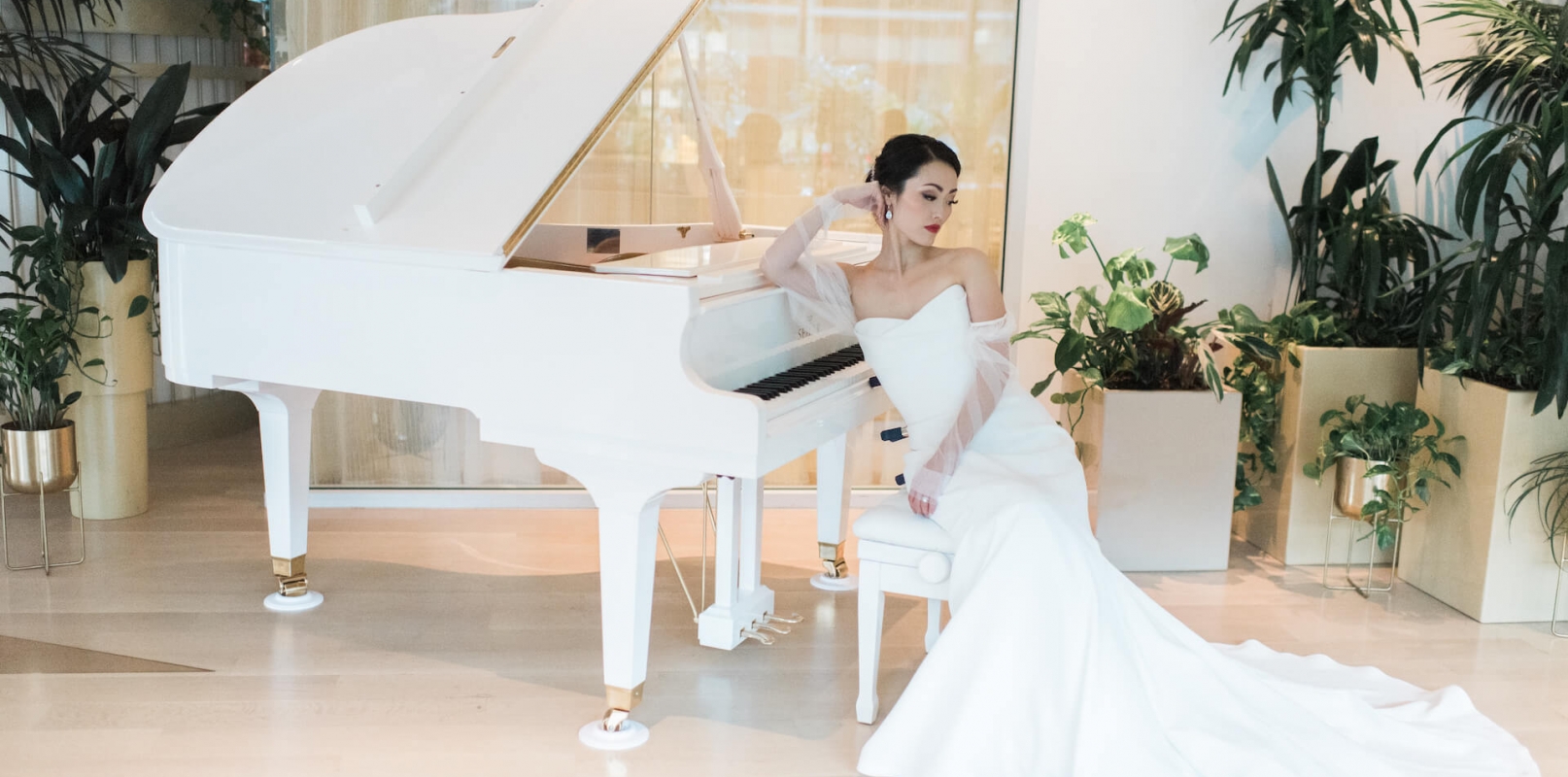 Bride leaning on a white piano