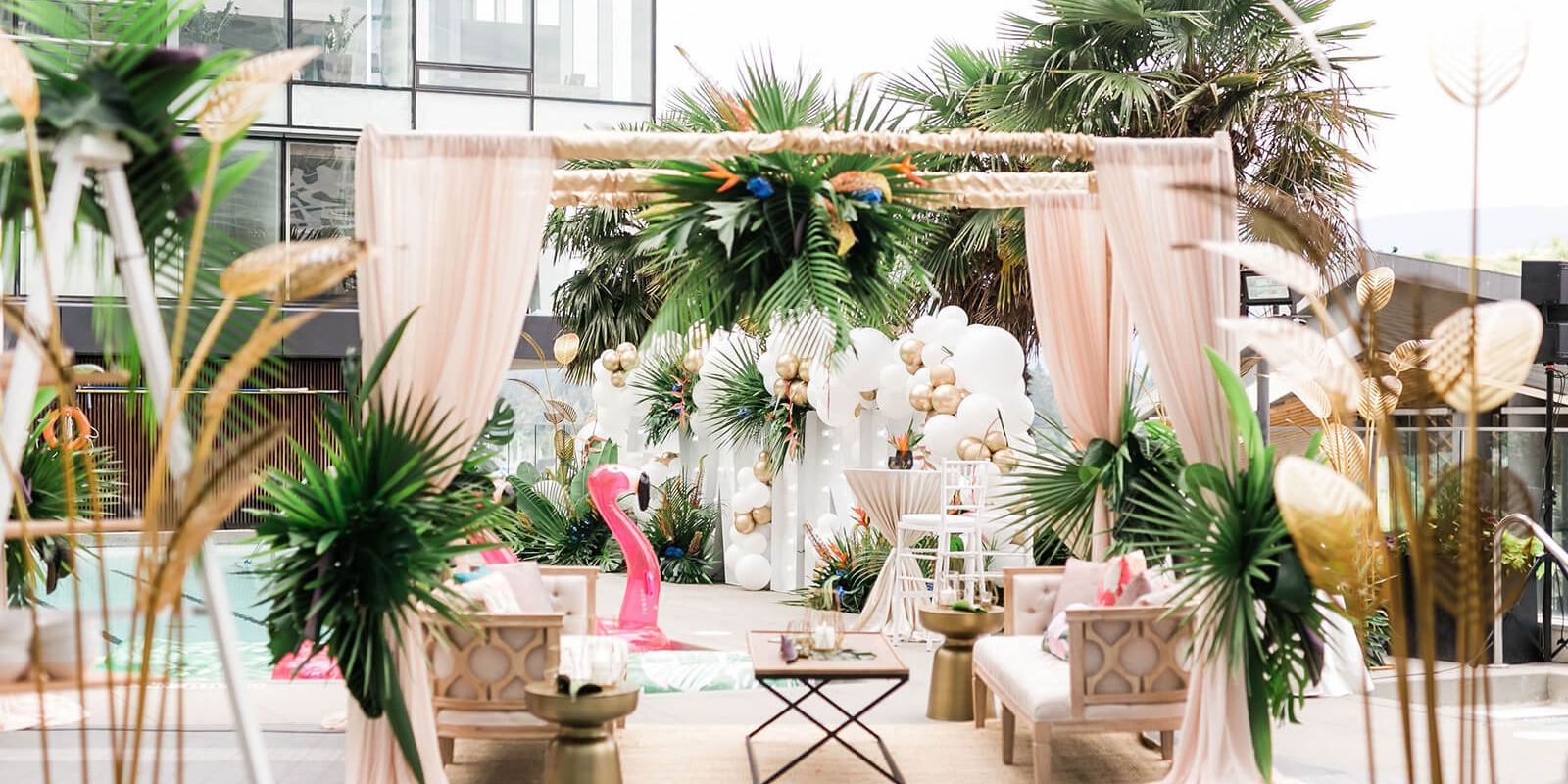 An outdoor pool patio decorated with white and gold balloons