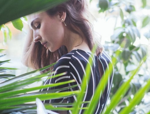 woman looking down among greenery