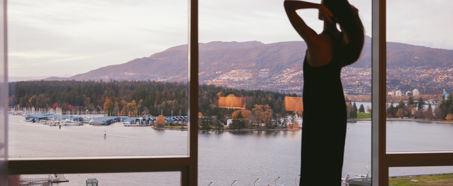 Woman overlooking the North Shore mountains from a luxury hotel in Vancouver