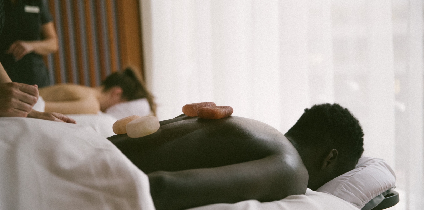 A man and a woman getting a hot stone massage