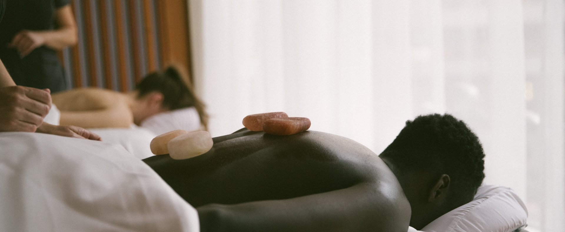 A man and a woman getting a hot stone massage