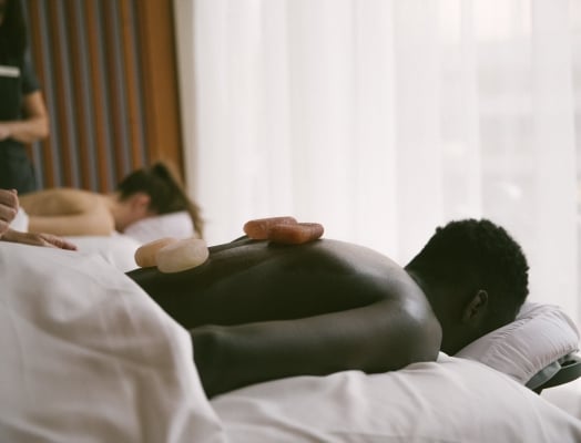 A man and a woman getting a hot stone massage