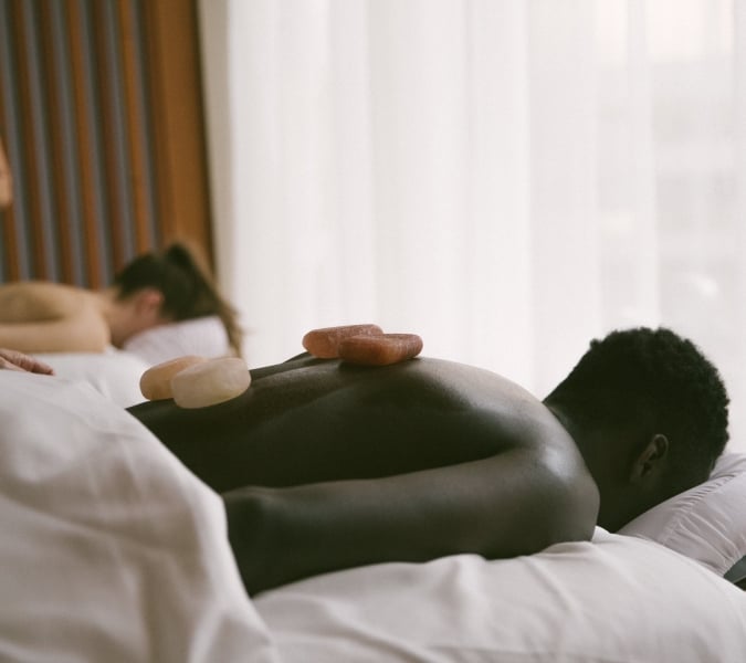 A man and a woman getting a hot stone massage