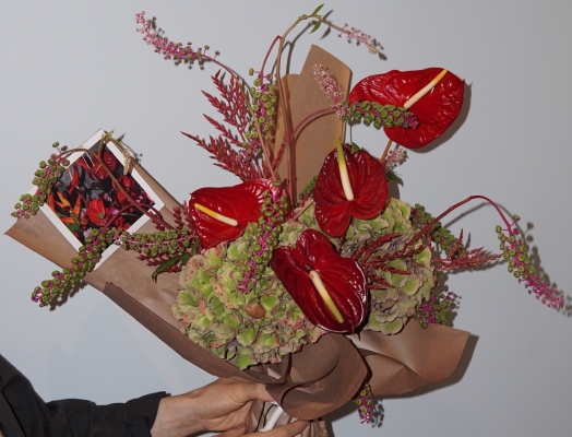 A person holding a flower bouquet from La Bomba Floristry