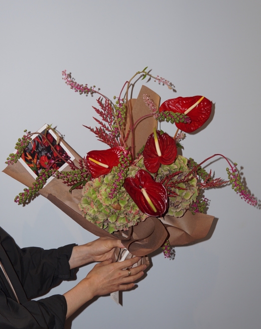 A person holding a flower bouquet from La Bomba Floristry