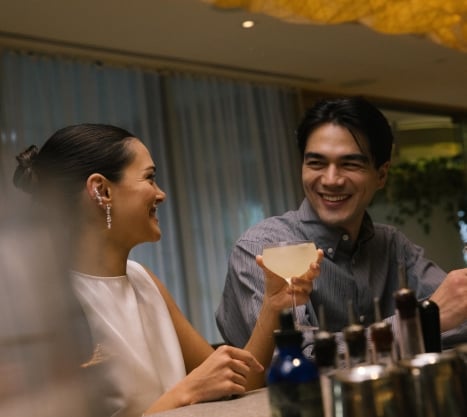Man and woman sitting at Botanist Bar enjoying a cocktail in Vancouver